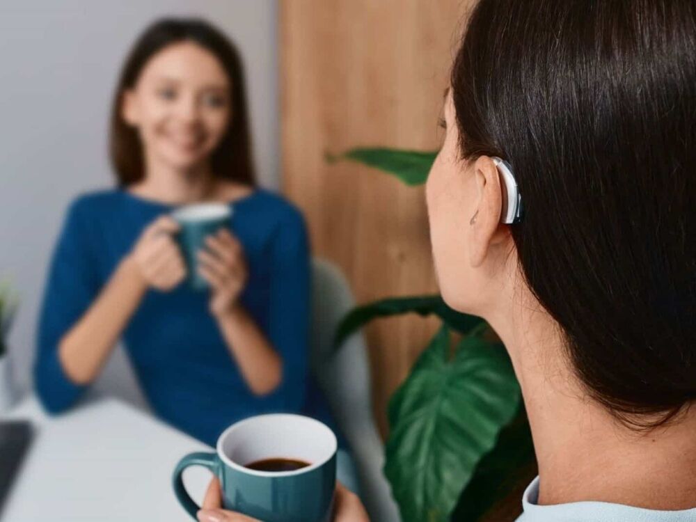Woman wearing a receiver-in-canal hearing aid, one of the hearing aid styles fitted at Optimum Audiology in Apple Valley, CA