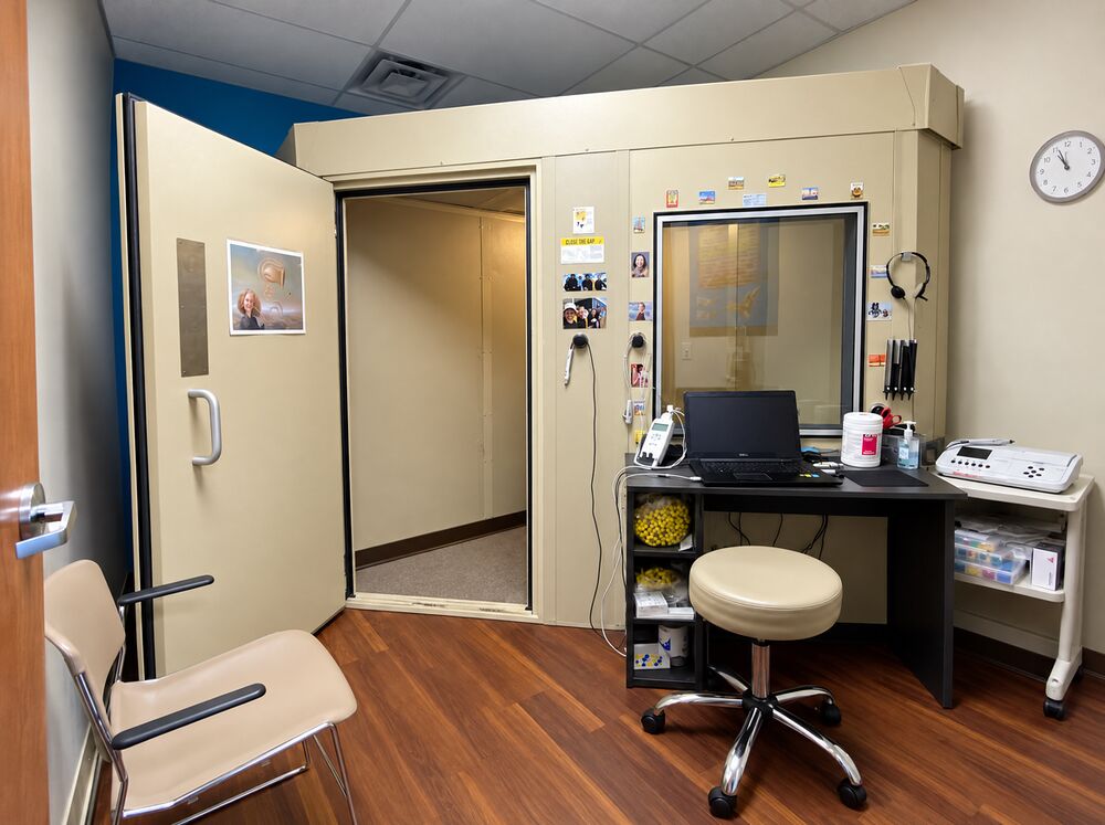 Sound-treated audiometric booth and testing equipment for hearing evaluations at Optimum Audiology in Apple Valley, CA