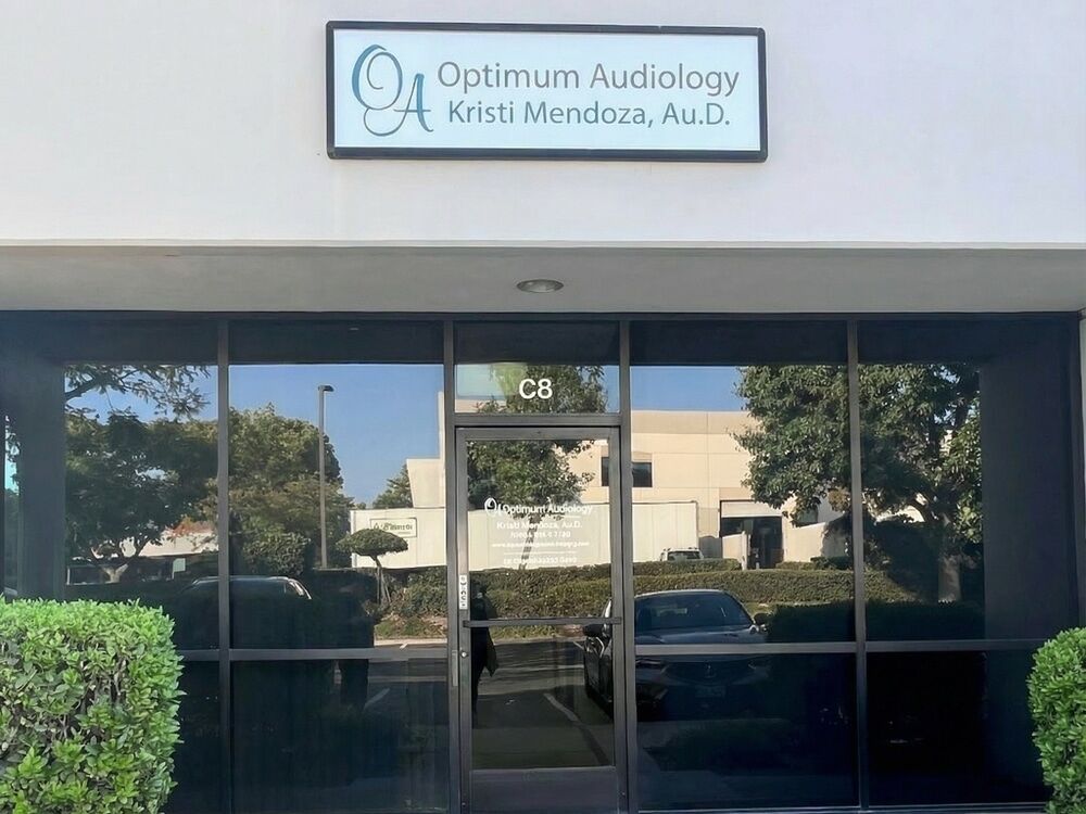 Suite C8 storefront with Optimum Audiology and Kristi Mendoza, Au.D. sign in the La Verne Business Park, La Verne, CA