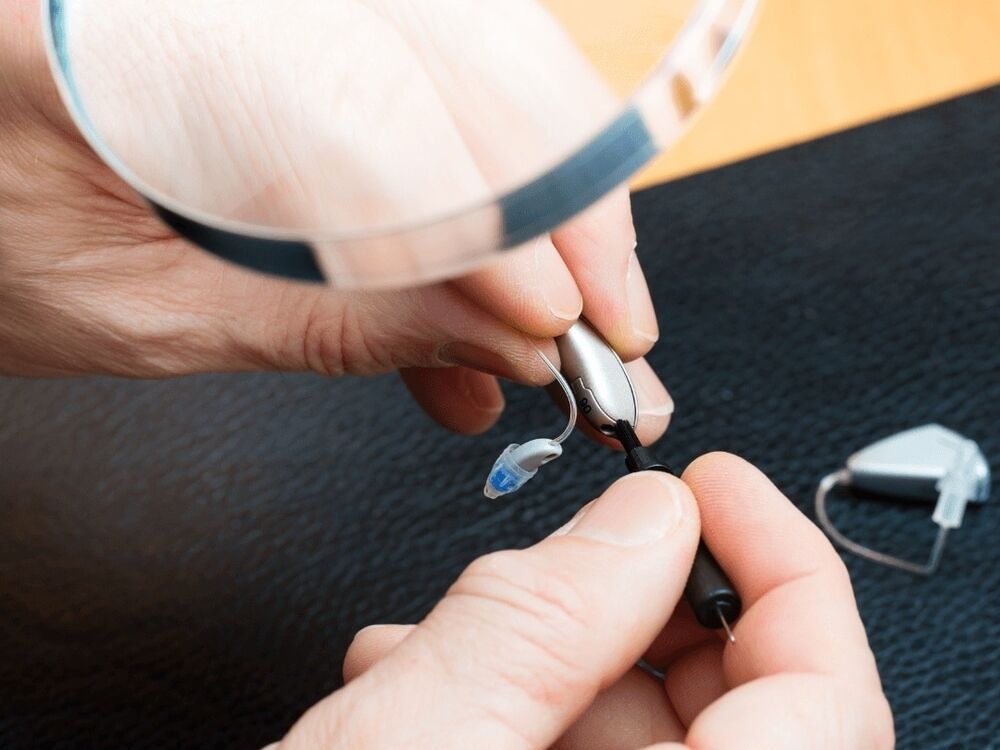 Hearing aid being cleaned and repaired in the office at Optimum Audiology in Apple Valley, CA